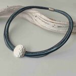 Ledercollier mit einer gehämmerter Scheibe in blau