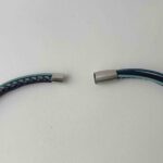 das Ledercollier mit einer gehämmerter Scheibe in einem blau