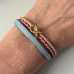 das Armband mit Fisch Gold in hellblau-rosa