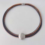 Ledercollier mit einer gehämmerter Scheibe in Navy und cognac