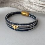 das Lederarmband mit einer goldener Biene blau-grau