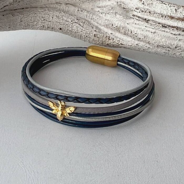 das Lederarmband mit einer goldener Biene blau-grau