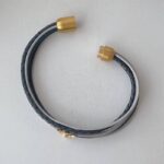 das Lederarmband mit goldener Biene blau-grau