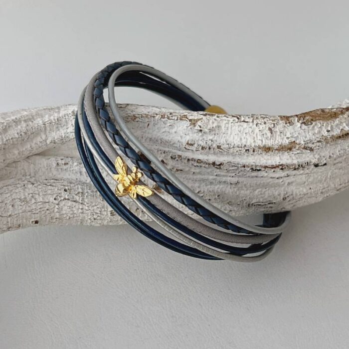 das Lederarmband mit einer goldener Biene in blau-grau