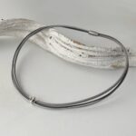 das Ledercollier mit Biene in grau