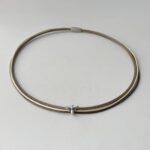 das Ledercollier mit einer Biene in taupe