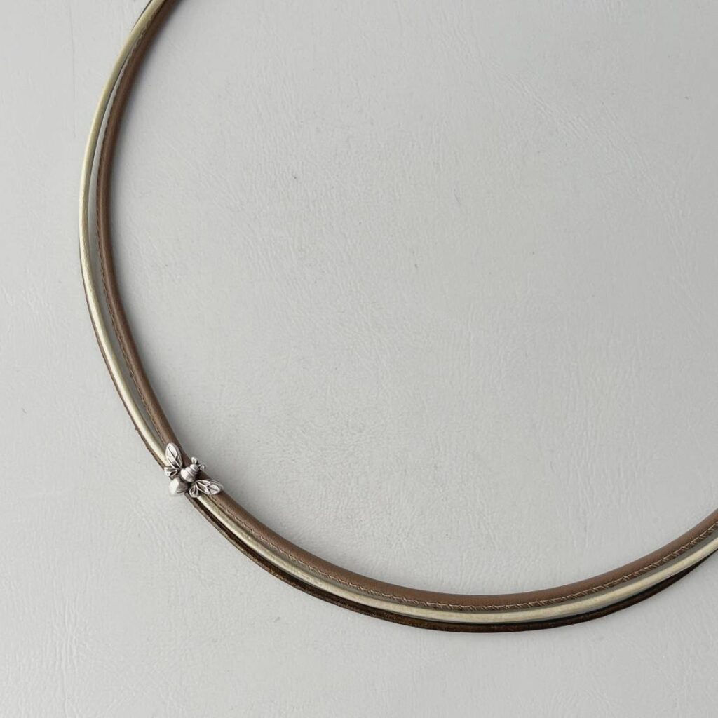 das Ledercollier mit einer Biene taupe