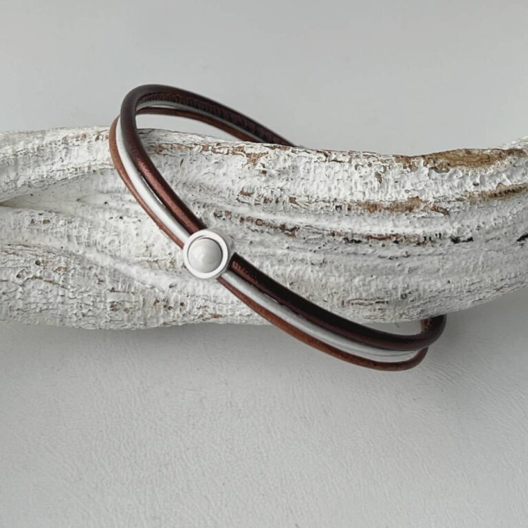 das Lederarmband in braun mit einem weißem Stein