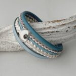 das Lederarmband mit einer Muschel in hellblau weiß