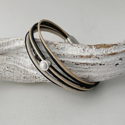 das Lederarmband in schwarz und beige mit weißem Stein