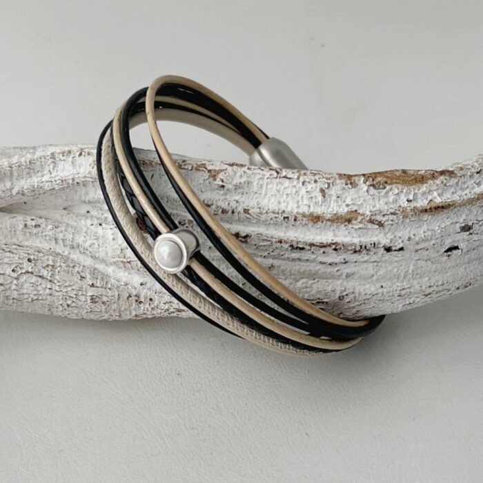 das Lederarmband in schwarz und beige mit weißem Stein