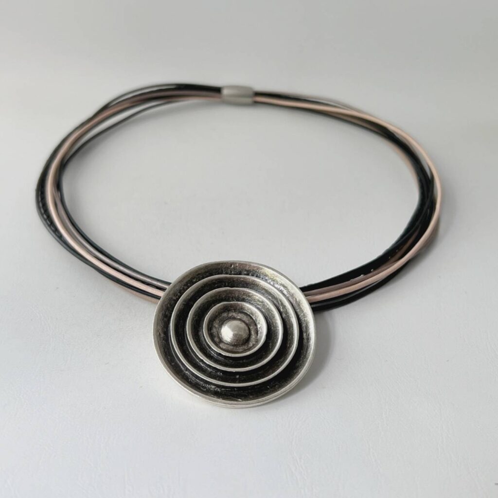 das schöne Ledercollier mit einem 3D Anhänger in schwarz-beige